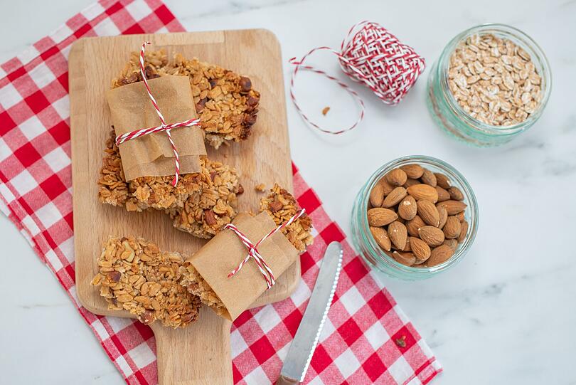 Wer morgens keine Zeit für ein ausgiebiges Frühstück hat, kann einen selbstgemachten Mandel-Müsliriegel zum Mitnehmen vorbereiten. Die Riegel liefern genug Energie und verdauungsfördernde Ballaststoffe - ohne unnötig viel Zucker. Für das Rezept 150 Gramm Haferflocken, 75 Gramm Sonnenblumenkerne, 125 Gramm Mandeln und 50 Gramm Sesamsamen bei 180 Grad im Ofen rösten. Wer morgens keine Zeit für ein ausgiebiges Frühstück hat, kann einen selbstgemachten Mandel-Müsliriegel zum Mitnehmen vorbereiten. Die Riegel liefern genug Energie und verdauungsfördernde Ballaststoffe - ohne unnötig viel Zucker. Für das Rezept 150 Gramm Haferflocken, 75 Gramm Sonnenblumenkerne, 125 Gramm Mandeln und 50 Gramm Sesamsamen bei 180 Grad im Ofen rösten.