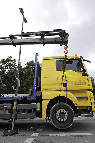 Sie sicherten ihren Lkw mit den Kranstützen ab und hoben mit dem Selbstladekran den rechten Vorderreifen an.