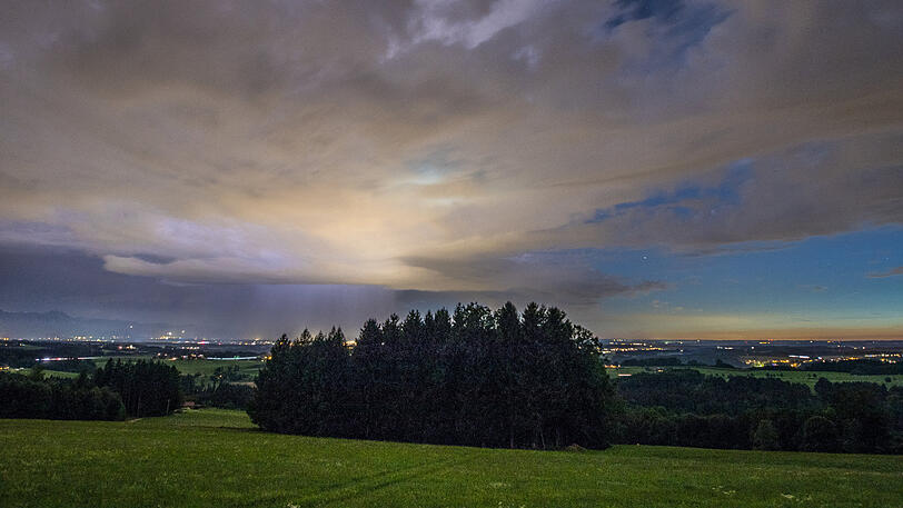 Bereits am frühen Abend ist die Lichtglocke von Rosenheim von der Ratzinger Höhe aus zu sehen.