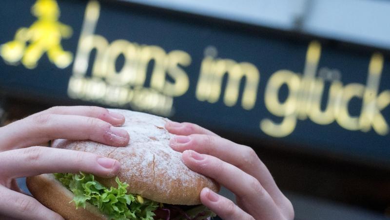 Eine junge Frau hält einen Burger der Burger-Kette "Hans im Glück" in den Händen. Foto: Matthias Balk/dpa/Archivbild Eine junge Frau hält einen Burger der Burger-Kette "Hans im Glück" in den Händen. Foto: Matthias Balk/dpa/Archivbild