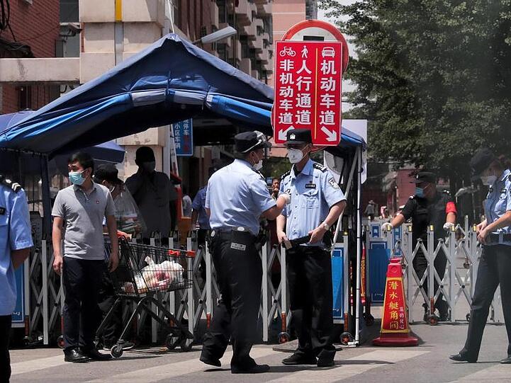 Polizisten und Sicherheitsbeamte vor abgeriegelten Wohngebäuden in der chinesischen Hauptstadt.