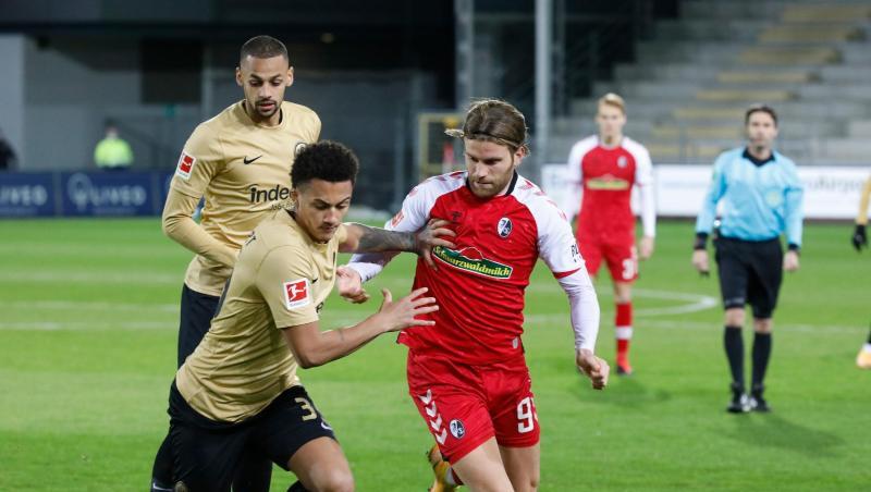 Der Freiburger Lucas Höler (M.) im Zweikampf mit dem Frankfurter Tuta.