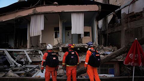 Mitglieder eines britischen Rettungsteams suchen im türkischen Antakya nach Überlebenden.