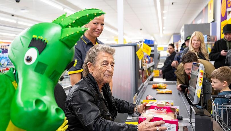 Der Musiker Peter Maffay (M) sitzt als Kassierer in einer Filiale des Netto Marken-Discounts.