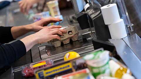 Ein Kassierer arbeitet in einem Supermarkt: Die Inflationsrate sinkt.