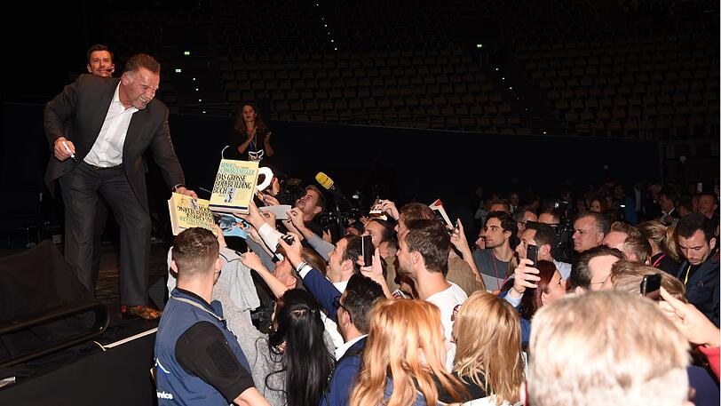 Arnold Schwarzenegger gibt Autogramme.