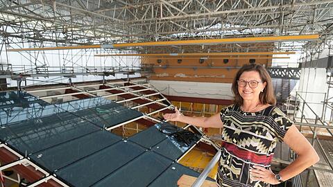 Landtagspräsidentin Ilse Aigner deutet auf das neue Dach des Plenarsaals. Jede der insgesamt 101 Glasplatten wiegt 650 Kilogramm. Zwischen Saal und Dach wurde für die Arbeiten aus Sicherheitsgründen eine Zwischendecke eingezogen. Eine Wellblech-Konstruktion soll Handwerker und Material zudem vor Hitze und Regen schützen. Ende des Jahres soll alles fertig sein.
