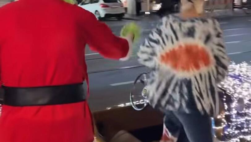 Der Grinch holte Verena Kerth auf der Maximilianstra&szlig;e ab und half ihr beim Einsteigen in seinen leuchtenden Zweisitzer.