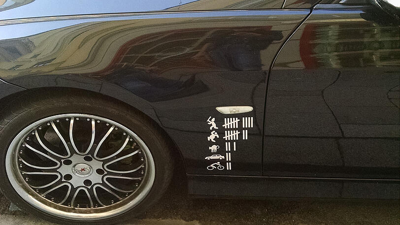 Die Aufkleber auf dem schwarzen BMW sind nicht verboten. Aber sie zeichnen das Bild eines verrohten Menschen mit rechter Gesinnung.