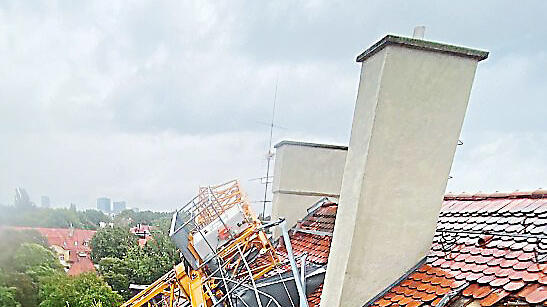 Der Ausleger des Krans hat die beiden Wohngebäude schwer beschädigt.  Berufsfeuerwehr