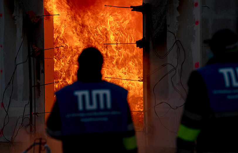 Wissenschaftler der Technischen Universität München beobachten einen Großbrandversuch. Bei dem Versuch wurde ein Wohnungsbrand in einem Holzhaus simuliert.