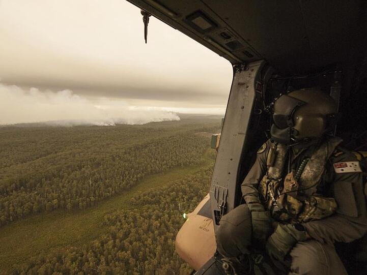 Ein Soldat schaut aus einem Militärhubschrauber auf die Brände im Bundesstaat Victoria.