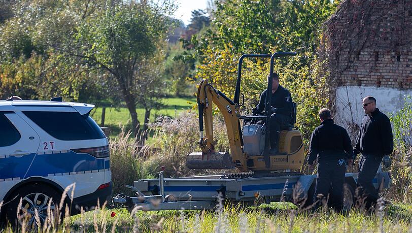 Polizisten untersuchen mit einem Bagger ein Grundstück in Herzberg (Landkreis Oder-Spree).
