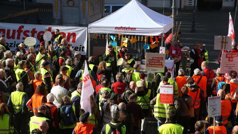 Demonstranten in bunten Westen stehen vor dem Düsseldorfer Rathaus. Demonstranten in bunten Westen stehen vor dem Düsseldorfer Rathaus.