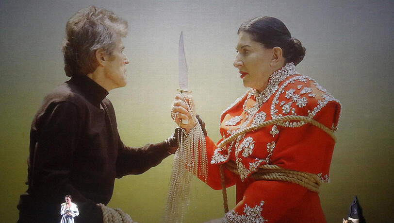 "7 Deaths of Maria Callas" verbindet Opernarien mit Filmen und einer Performance: Nadeszhda Karyazina singt die Habanera aus "Carmen", ganz rechts schläft Marina Abramović als Callas, in der Projektion kämpfen Mann und Frau (Willem Dafoe und Marina Abramović) gegeneinander und mit tödlichen Ausgang. "7 Deaths of Maria Callas" verbindet Opernarien mit Filmen und einer Performance: Nadeszhda Karyazina singt die Habanera aus "Carmen", ganz rechts schläft Marina Abramović als Callas, in der Projektion kämpfen Mann und Frau (Willem Dafoe und Marina Abramović) gegeneinander und mit tödlichen Ausgang.