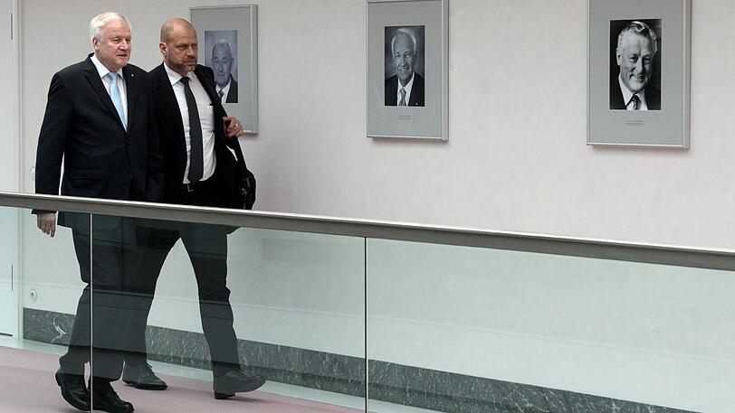 Horst Seehofer und ein Sicherheitsmann geht auf dem Weg zu seiner letzten Ministerrats-Sitzung an den Porträts seiner Vorgänger im Amt des Bayerischen Ministerpräsidenten vorbei (v.l.): Günther Beckstein (2007 &ndash; 2008), Edmund Stoiber (1993 &ndash; 2007) und Max Streibl (1988 &ndash; 1993).