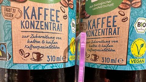 Flaschen mit Kaffeekonzentrat stehen in einem Drogeriemarktregal. (Archivbild)