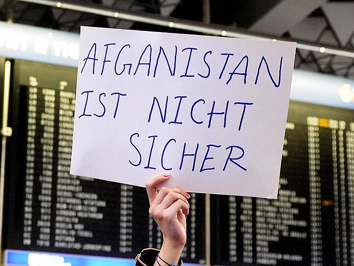 Eine Demonstrantin hält ein Plakat mit der Aufschrift "Afghanistan ist nicht sicher" in die Höhe. Foto: Susann Prautsch/Archivbild