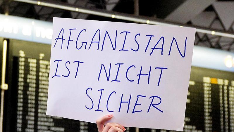 Eine Demonstrantin hält ein Plakat mit der Aufschrift "Afghanistan ist nicht sicher" in die Höhe. Foto: Susann Prautsch/Archivbild