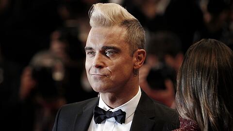 Robbie Williams auf dem Roten Teppich einer Veranstaltung.