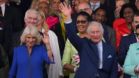 Der britische König Charles und Königin Camilla winken beim Konzert auf Schloss Windsor.