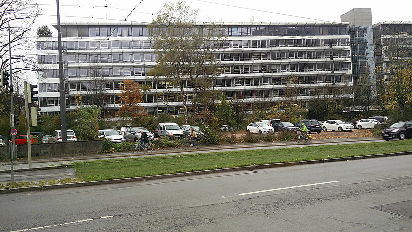 Das Gelände wird inzwischen als Parkplatz benutzt. Im Hintergrund ist das Technische Rathaus zu sehen.