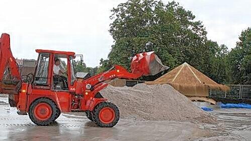 Ein großer Radlader schiebt den Sand zu einem riesigen Haufen zusammen. Ein großer Radlader schiebt den Sand zu einem riesigen Haufen zusammen.