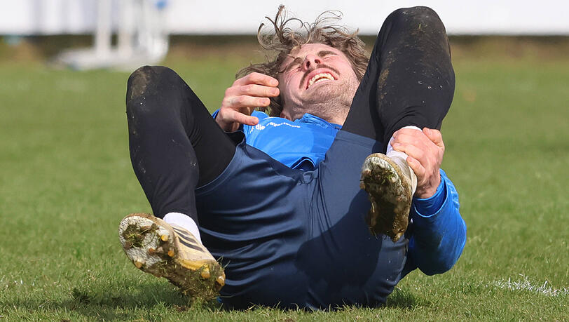 David Philipp liegt verletzt am Boden des 1860-Trainingsplatzes Nummer eins. Trainer Kauczinski: "Der Boden ist sehr hart. Das ist auch ein Puzzleteil f&uuml;r unsere Verletzungen."
