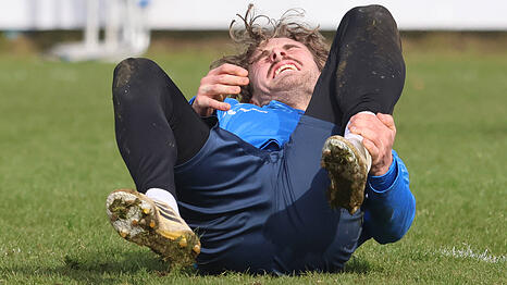 David Philipp liegt verletzt am Boden des 1860-Trainingsplatzes Nummer eins. Trainer Kauczinski: "Der Boden ist sehr hart. Das ist auch ein Puzzleteil f&uuml;r unsere Verletzungen."