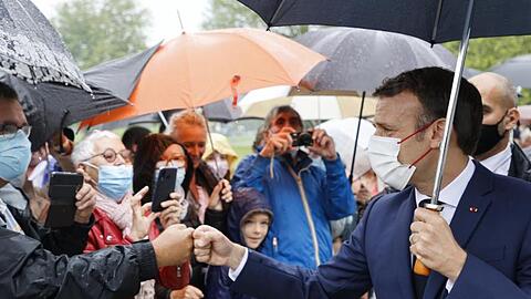 Emmanuel Macron (r), Präsident von Frankreich, begrüßt Anwohner bevor er seine Stimme in einem Wahllokal abgibt.