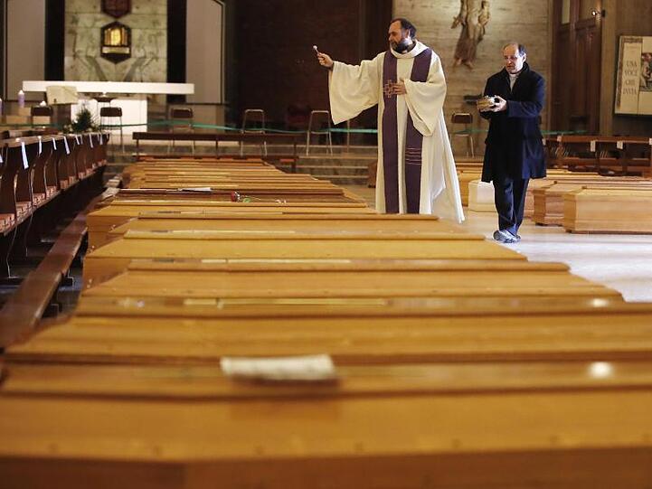 Ein Priester segnet Särge in Seriate, einer Gemeinde in der italienischen Provinz Bergamo.