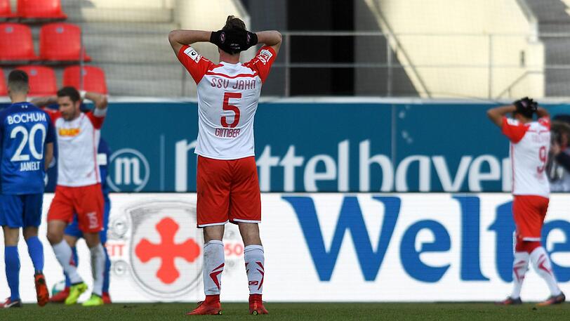 Enttäuscht stehen Spieler von Jahn Regensburg nach der Niederlage gegen den VfL Bochum auf dem Spielfeld.