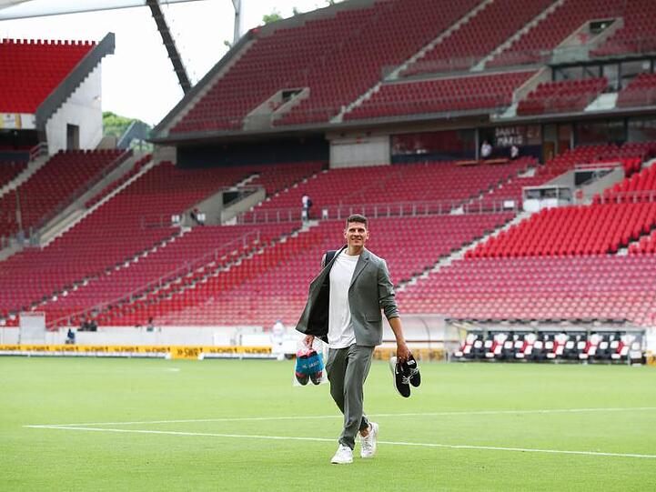 Mario Gomez hat seine Fußballschuhe ausgezogen und verlässt das Spielfeld.