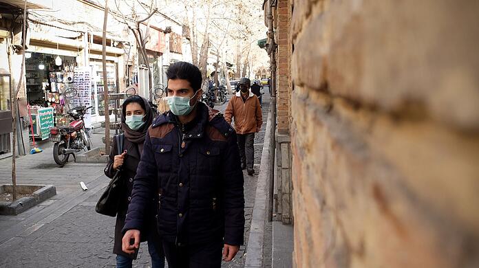 Ein iranisches Paar geht im Stadtteil Shapour im Süden Teherans die Straße entlang.