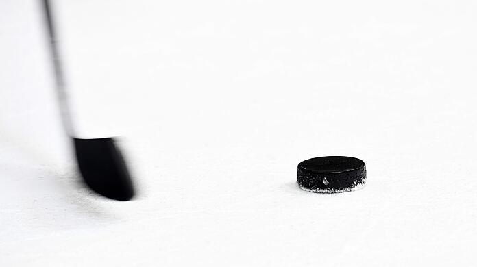 Ein Puck und ein Eishockeyschläger.
