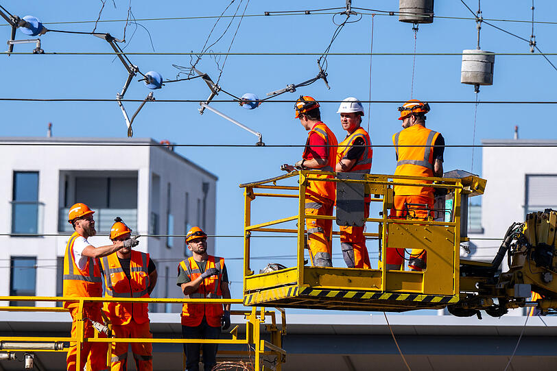 Arbeiter reparieren am Bahnhof Laim eine abgerissene Oberleitung.