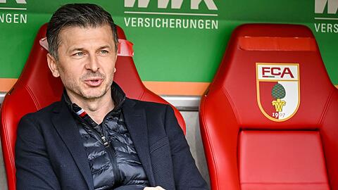 Augsburgs Sportdirektor Marinko Jurendic sitzt vor dem Spiel auf der Bank.