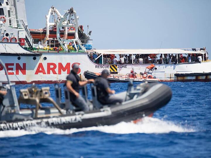 Ein Schlauchboot der der italienischen Küstenwache fährt um das Rettungsschiff "Open Arms" herum.