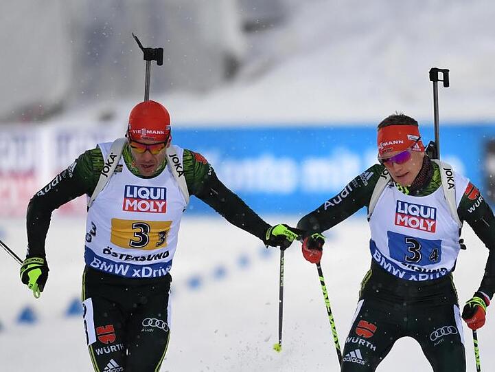 Deutschlands Arnd Peiffer (l) übergibt bei der Mixed-Staffel an Schlussläufer Benedikt Doll.