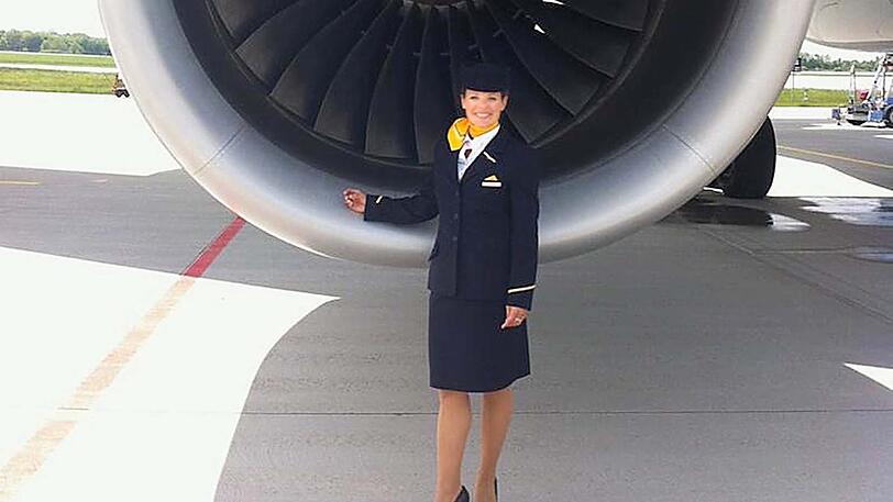 Die Stewardess Annika Wittmann vor der Turbine ihres Flugzeugs.