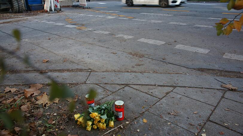 Die Unfall-Kreuzung am Tag danach: An der Chiemgaustraße Ecke Scharfreiterplatz ist am Mittwochabend eine junge Frau bei einem Unfall tödlich verletzt worden. Menschen haben vor Ort Blumen und Kerzen abgelegt.