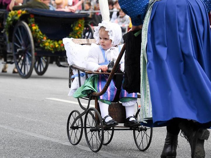Ein Kind im historischen Outfit und einem ebensolchen Kinderwagen wird geschoben. Foto: Tobias Hase/Archiv