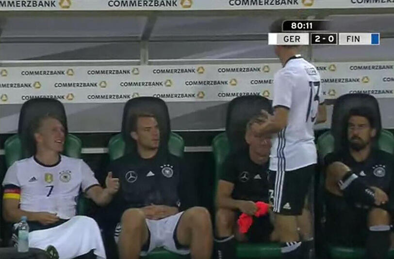 Nach einigen Minuten merkt er, dass er noch seinen Ehering trägt. Er rennt zur Bank und möchte ihn Bastian Schweinsteiger (l.) geben.