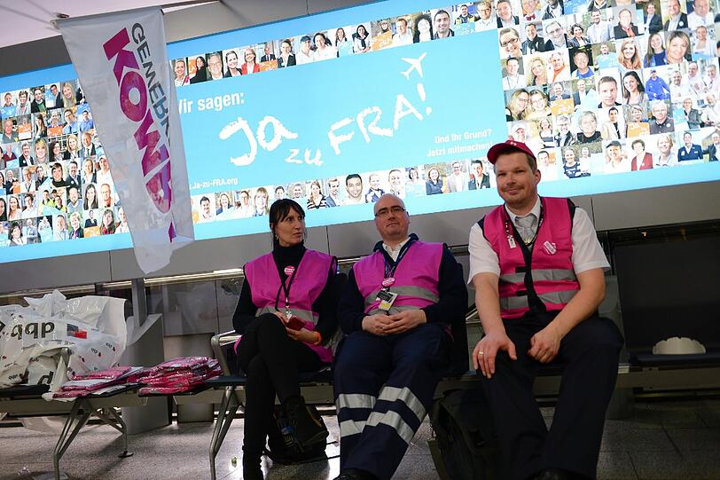 Mitglieder der Gewerkschaft Komba (Fachgewerkschaft des dbb beamtenbund und tarifunion für Beschäftigte im Kommunal- und Landesdienst) sitzen nahe eines Einlasses zur Sicherheitskontrolle zusammen.