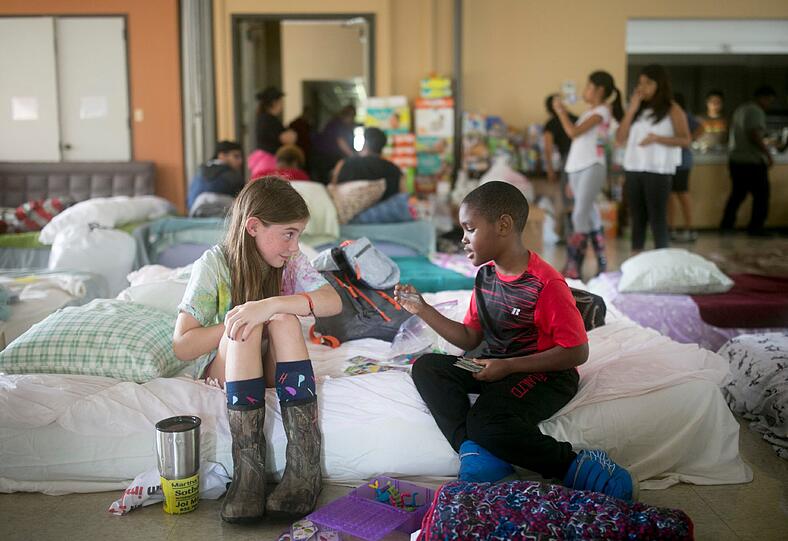 Die freiwillige Helferin Elizabeth Hill (8) spielt in einer Unterkunft in der St. Thomas Presbyterian Church in Houston mit dem wegen des Tropensturms evakuierten Skyler Smith (7).