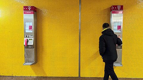 Zwei Wandtelefone am Bochumer Hauptbahnhof - mancher Passant bleibt stehen und blickt verwundert auf die alte Technik.
