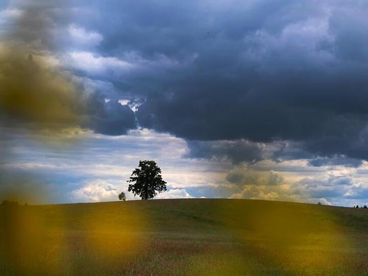 Dunkle Wolken ziehen über die Landschhaft bei Höhenrain im Landkreis Starnberg. Foto: Stephan Jansen/dpa/Archivbild