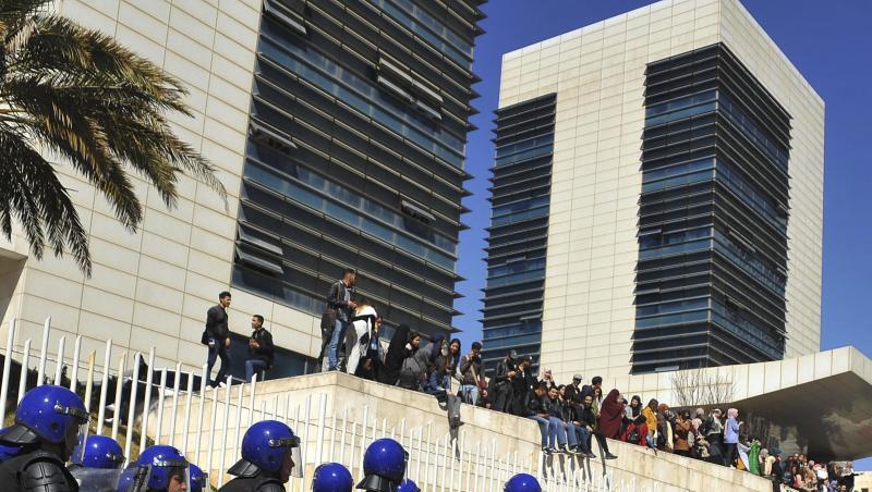 Polizisten sind in Algier aufgezogen und beobachten Demonstranten, die gegen eine erneute Kandidatur des algerischen Präsidenten Bouteflika protestieren. Polizisten sind in Algier aufgezogen und beobachten Demonstranten, die gegen eine erneute Kandidatur des algerischen Präsidenten Bouteflika protestieren.