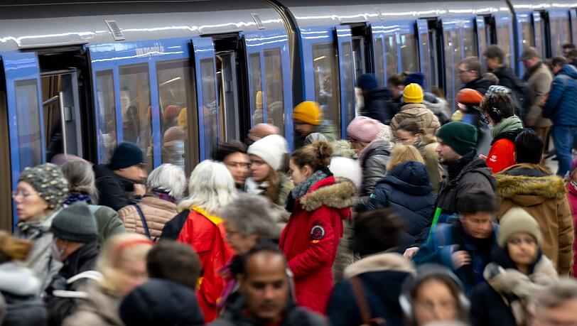 Fahrgäste steigen an einer Haltestelle in eine U-Bahn.