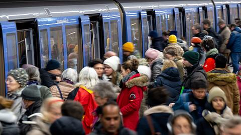 Fahrgäste steigen an einer Haltestelle in eine U-Bahn.